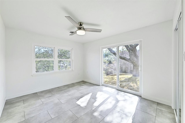 tiled spare room featuring ceiling fan