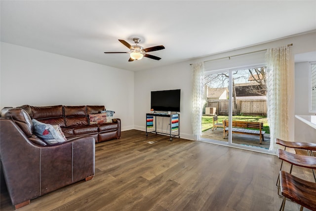 living room with dark hardwood / wood-style flooring and ceiling fan