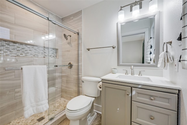 bathroom featuring an enclosed shower, vanity, and toilet