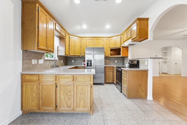 kitchen featuring stainless steel appliances, kitchen peninsula, sink, and light tile patterned floors