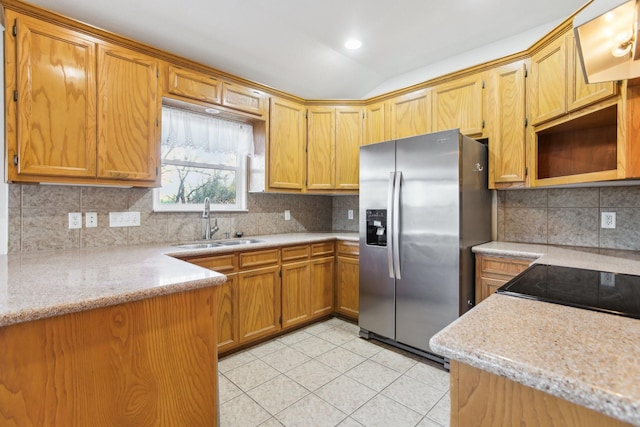 kitchen featuring sink, stainless steel fridge, and decorative backsplash