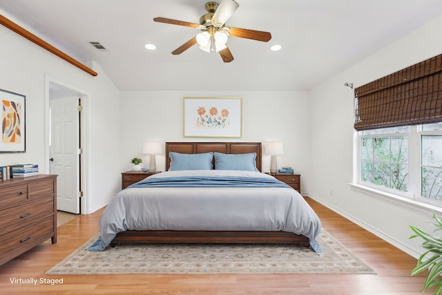 bedroom with vaulted ceiling, ceiling fan, and light hardwood / wood-style floors