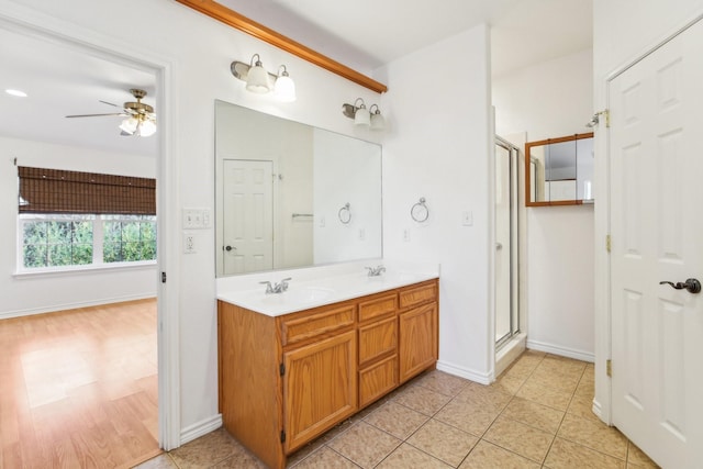 bathroom with ceiling fan, vanity, an enclosed shower, and tile patterned flooring