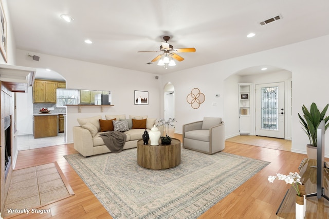 living room with ceiling fan and light hardwood / wood-style flooring