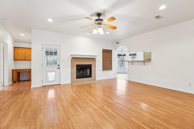 unfurnished living room featuring ceiling fan, plenty of natural light, and light hardwood / wood-style flooring