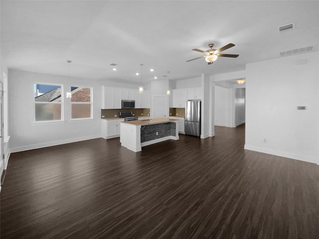 unfurnished living room with dark wood-type flooring, ceiling fan, and sink