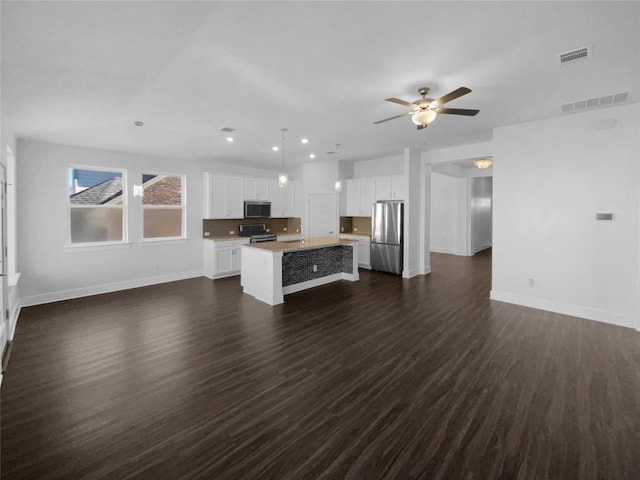 2120 Prairie Oaks Dr, Georgetown, TX 78628 - unfurnished living room featuring a ceiling fan, dark wood-type flooring, and recessed lighting