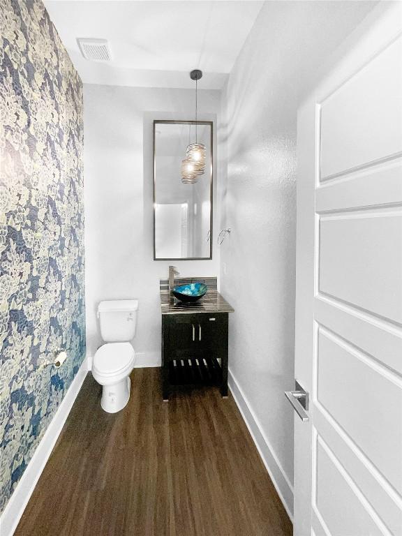 2120 Prairie Oaks Dr, Georgetown, TX 78628 - bathroom with wood finished floors, vanity, and wallpapered walls