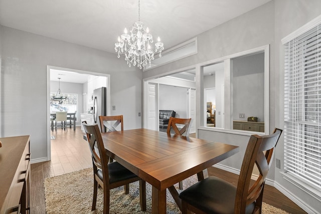 dining room featuring wood-type flooring and a chandelier