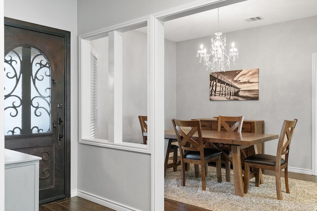 dining room with dark hardwood / wood-style flooring and a notable chandelier