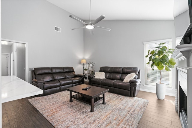 living room featuring hardwood / wood-style floors, high vaulted ceiling, and ceiling fan