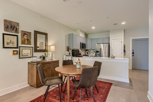 dining area featuring sink and light hardwood / wood-style floors