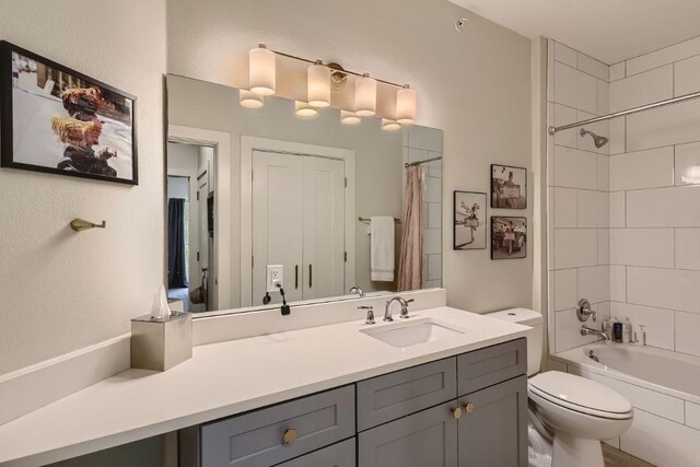 full bathroom featuring vanity, shower / tub combo with curtain, and toilet