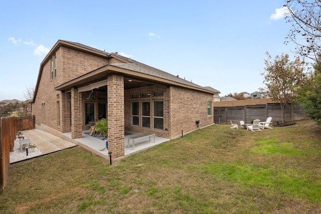 rear view of property with a yard and a patio