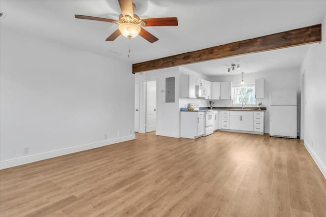 unfurnished living room with beamed ceiling, baseboards, light wood-style floors, and a sink