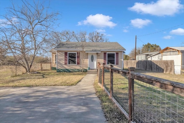 bungalow-style house with a fenced front yard and a front yard