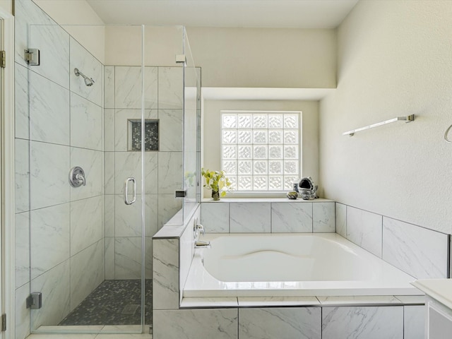 bathroom featuring shower with separate bathtub