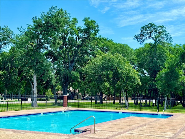 view of swimming pool featuring a yard