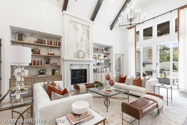 1304 Jolie Rose Bnd, Leander, TX 78641 - living room featuring a high ceiling, beam ceiling, a premium fireplace, an inviting chandelier, and built in shelves