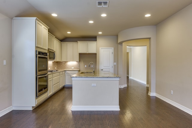 kitchen featuring sink, stainless steel appliances, light stone countertops, a kitchen island with sink, and white cabinets