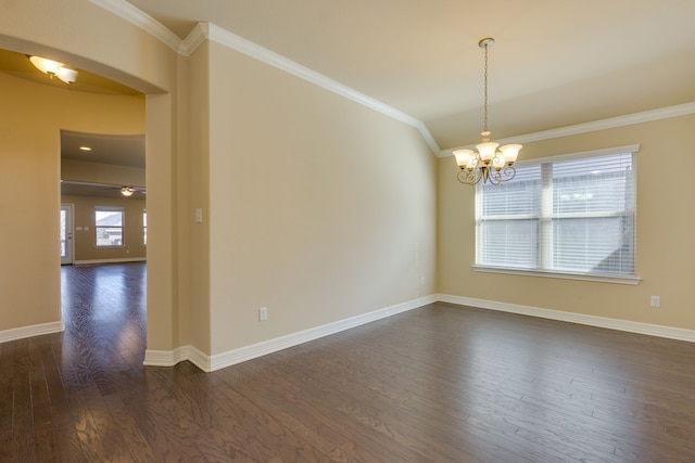 empty room featuring ornamental molding, dark hardwood / wood-style flooring, and a notable chandelier