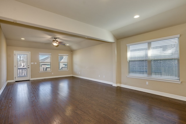 empty room with plenty of natural light, dark hardwood / wood-style floors, and vaulted ceiling