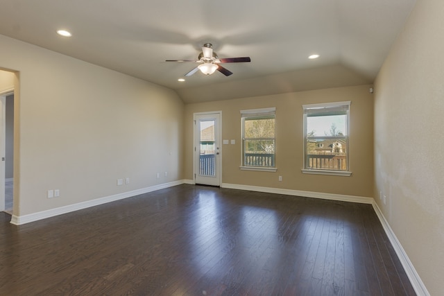 unfurnished room with ceiling fan, a healthy amount of sunlight, dark hardwood / wood-style floors, and vaulted ceiling