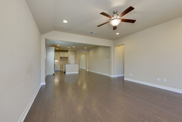 unfurnished living room with lofted ceiling, sink, dark hardwood / wood-style floors, and ceiling fan