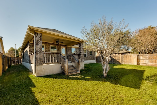 back of property with ceiling fan and a lawn