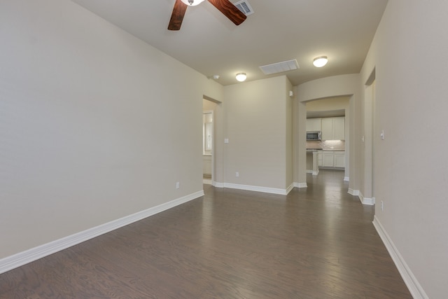 unfurnished living room with ceiling fan and dark hardwood / wood-style flooring