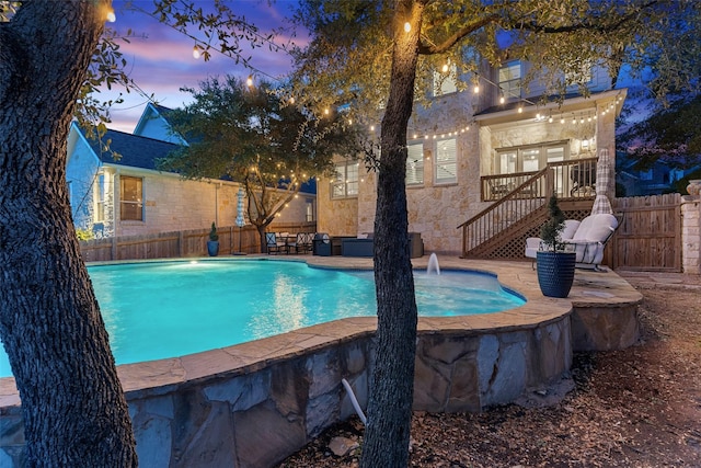 pool at dusk with pool water feature