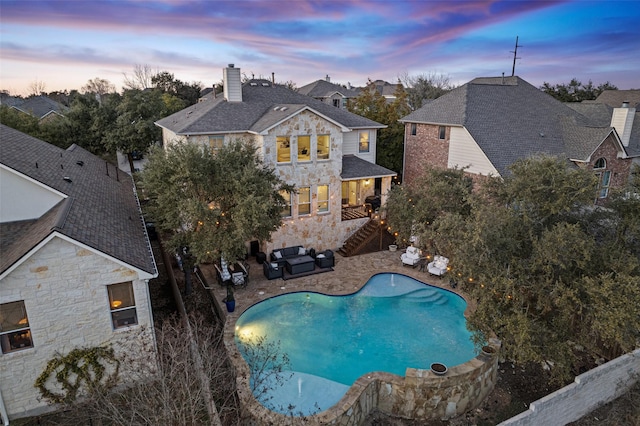 pool at dusk featuring a patio