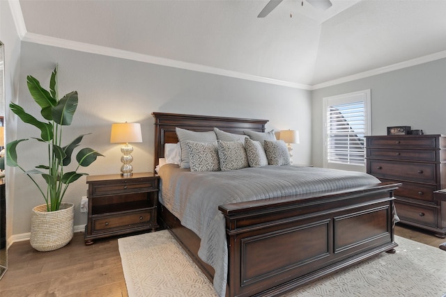 bedroom with lofted ceiling, crown molding, light hardwood / wood-style floors, and ceiling fan