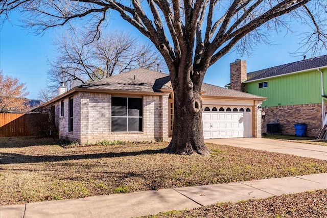 ranch-style house featuring a garage, a front yard, and central AC unit