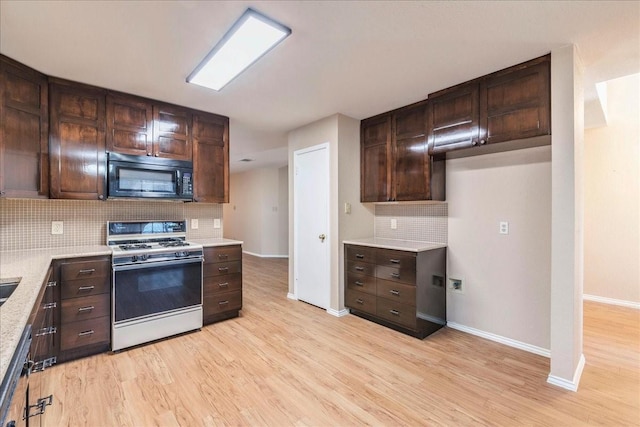 kitchen with dark brown cabinets, backsplash, light wood-type flooring, and gas range gas stove