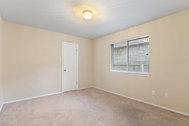 carpeted spare room featuring a textured ceiling