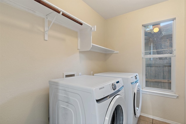 washroom featuring washing machine and dryer, plenty of natural light, and light tile patterned flooring