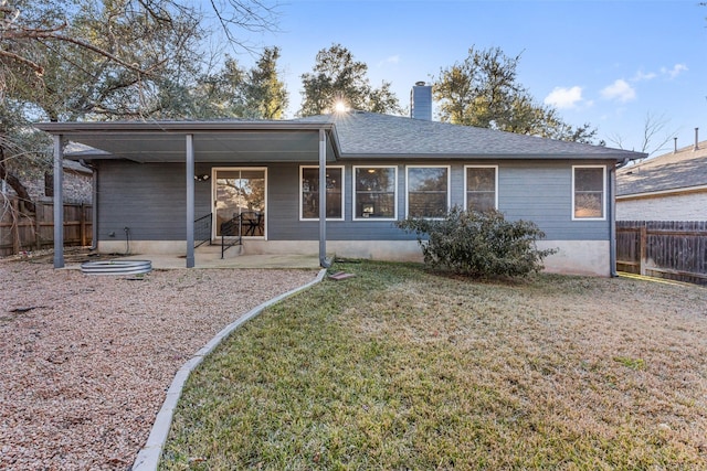 rear view of property featuring a patio and a lawn