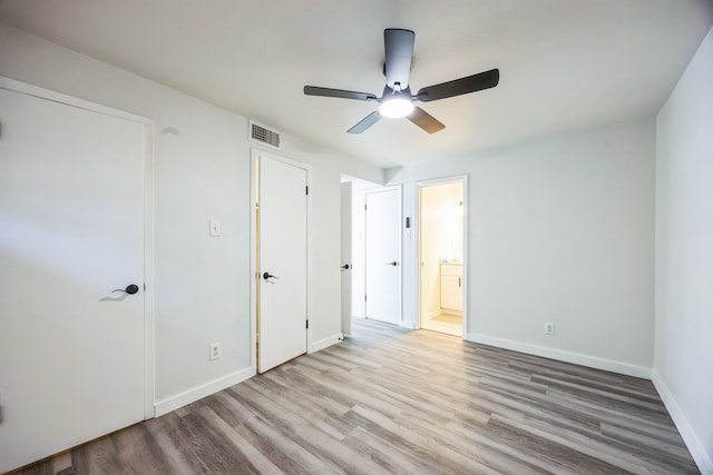 unfurnished bedroom featuring light hardwood / wood-style floors, ceiling fan, and ensuite bathroom