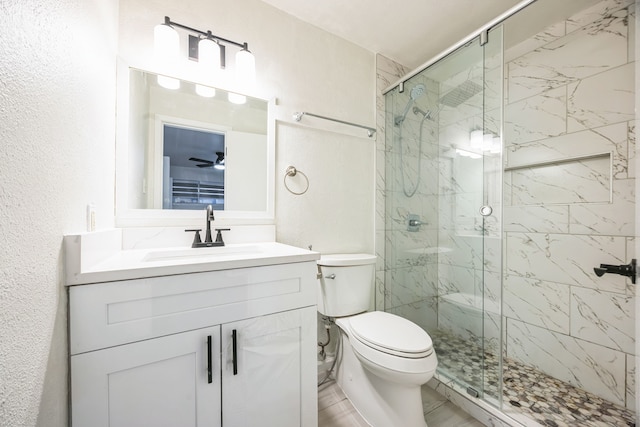 bathroom featuring vanity, a shower with door, and toilet