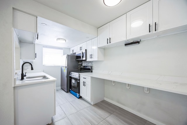 kitchen with white cabinetry, appliances with stainless steel finishes, sink, and backsplash