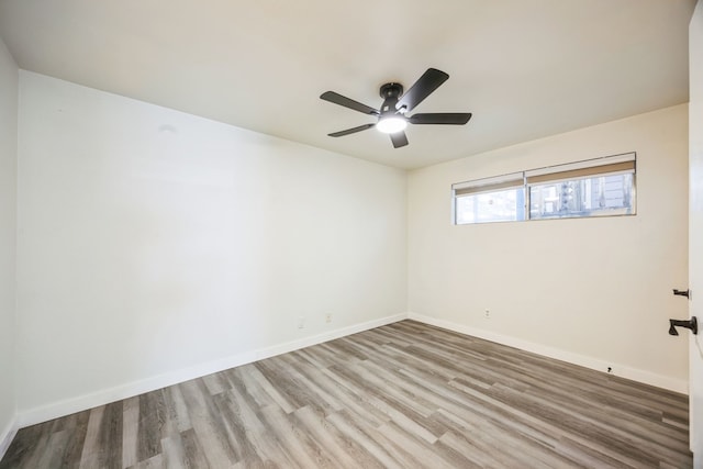 spare room with ceiling fan and light wood-type flooring