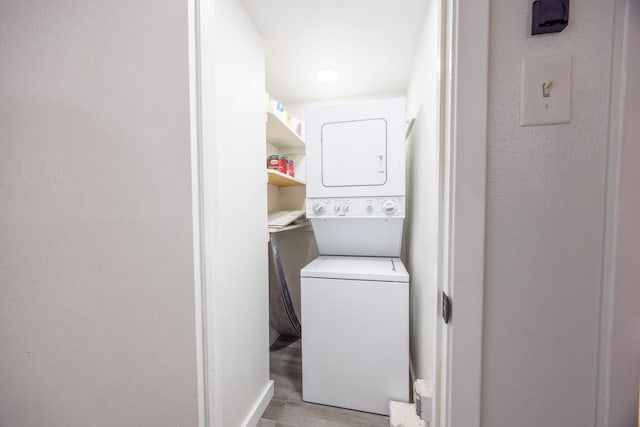 laundry room with light wood-type flooring and stacked washing maching and dryer