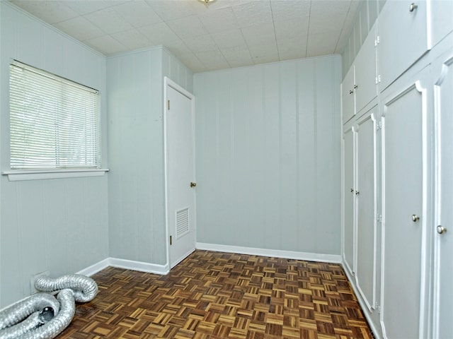 interior space featuring ornamental molding and dark parquet floors