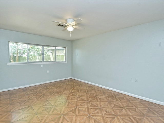 spare room featuring ceiling fan and light parquet floors