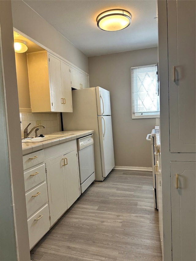 kitchen featuring sink, white cabinetry, white dishwasher, tile counters, and decorative backsplash