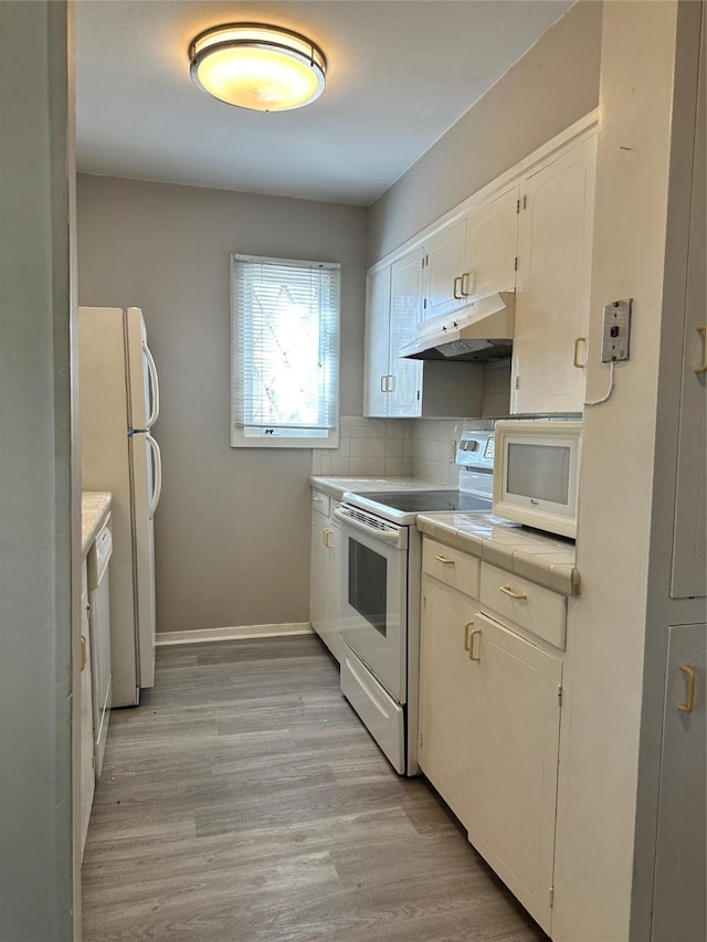 kitchen featuring tile counters, white cabinets, white appliances, light hardwood / wood-style floors, and backsplash