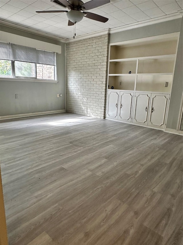 interior space with built in features, ornamental molding, ceiling fan, and light wood-type flooring