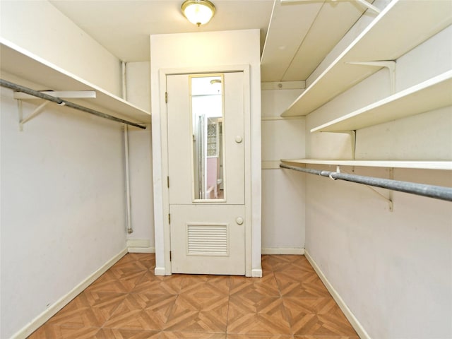 walk in closet featuring parquet floors