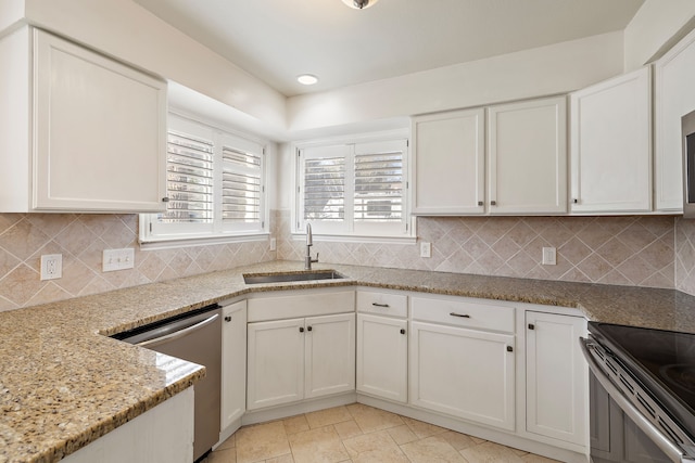 kitchen featuring white cabinetry, sink, light stone countertops, and appliances with stainless steel finishes